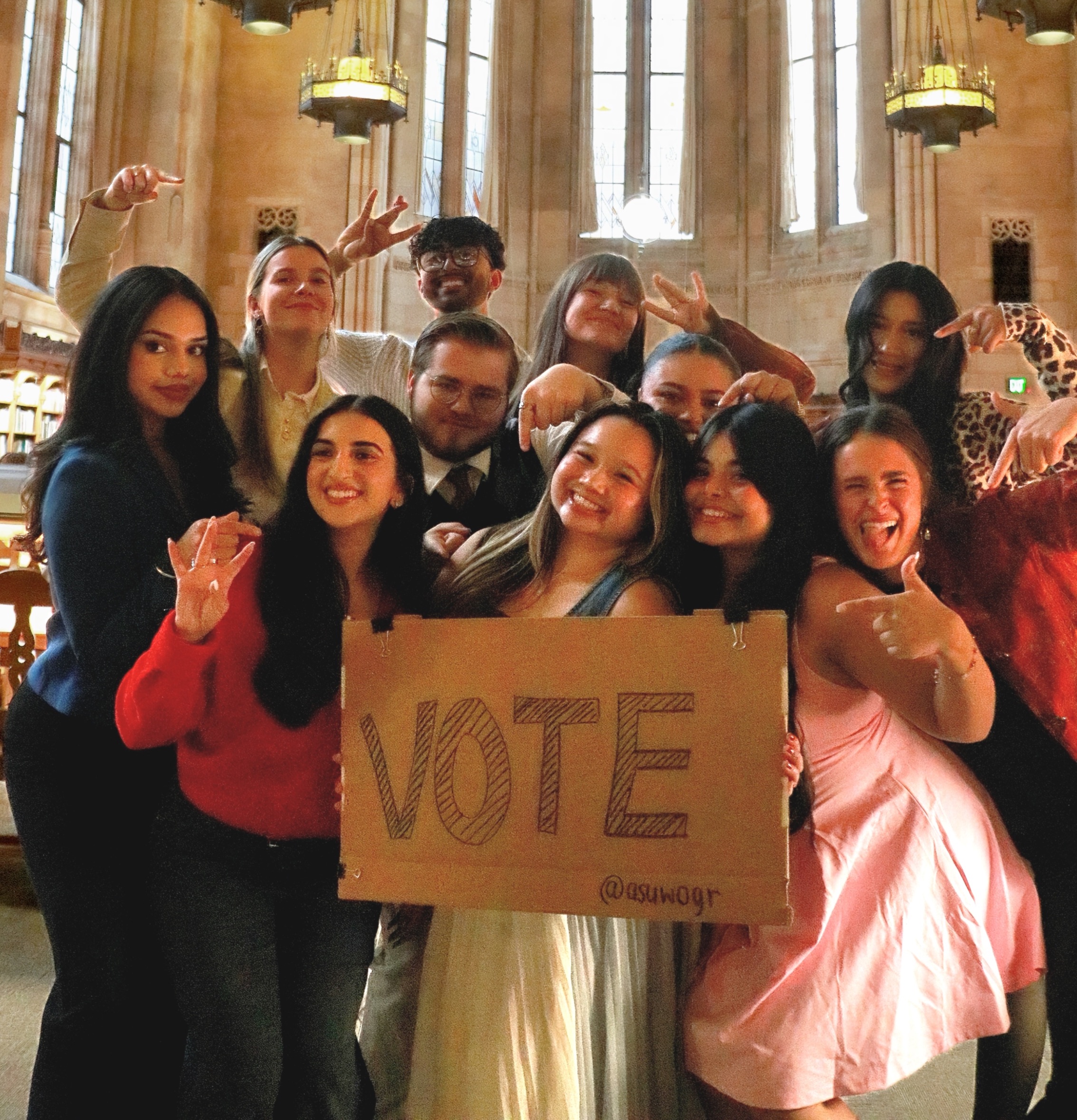The ASUW Board of Directors posing with a "Vote" sign.